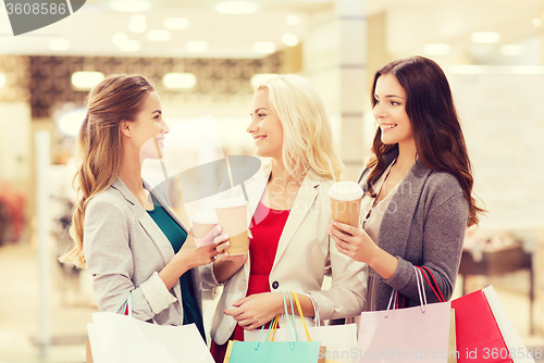 Image of young women with shopping bags and coffee in mall