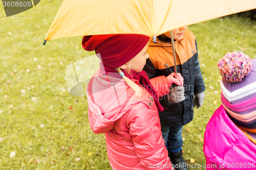 Image of close up of kids with umbrella in autumn park