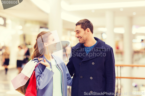 Image of happy young couple with shopping bags in mall