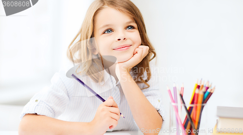 Image of girl drawing with pencils at school
