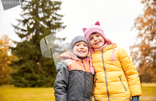 Image of happy little girl and boy in autumn park