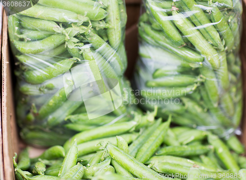 Image of close up of green peas in box at street market