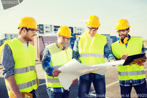 Image of group of builders with tablet pc and blueprint