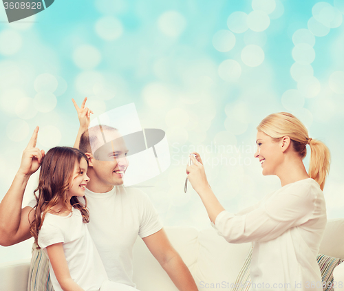 Image of happy family with camera at home