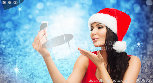 Image of woman in santa hat taking selfie by smartphone