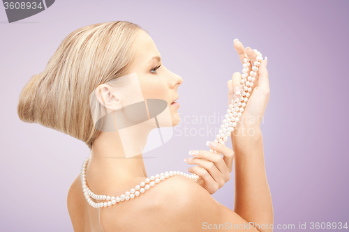 Image of beautiful woman with pearl necklace over violet