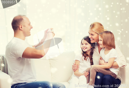 Image of happy family with camera taking picture at home