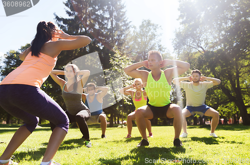 Image of group of friends or sportsmen exercising outdoors