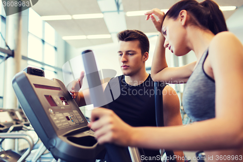 Image of woman with trainer exercising on stepper in gym