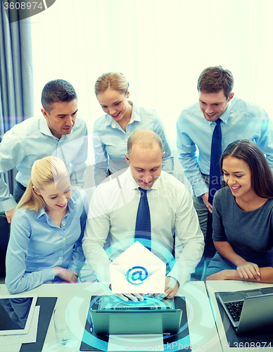 Image of smiling business people with laptop in office