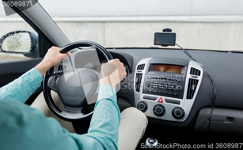 Image of close up of young man driving car