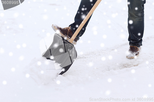 Image of closeup of man digging snow with shovel