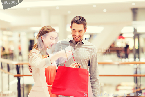 Image of happy young couple with shopping bags in mall