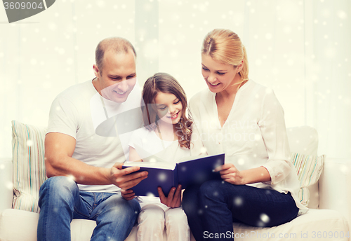 Image of happy family with book at home