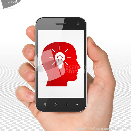 Image of Business concept: Hand Holding Smartphone with Head With Light Bulb on display