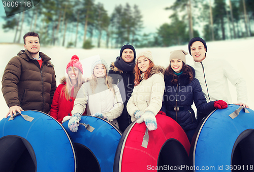 Image of group of smiling friends with snow tubes