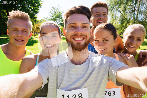 Image of happy friends taking selfie with smartphone