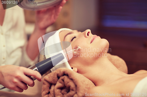 Image of close up of young woman having face massage in spa