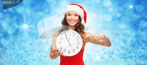 Image of woman in santa helper hat with clock showing 12