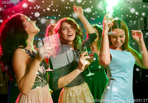 Image of smiling friends with glasses of champagne in club