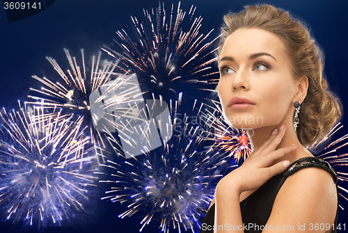 Image of beautiful woman wearing earrings over firework