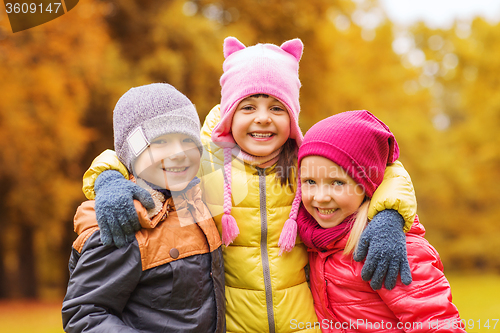 Image of group of happy children hugging in autumn park