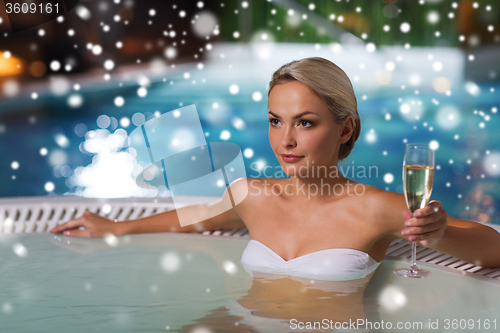 Image of happy woman drinking champagne at swimming pool