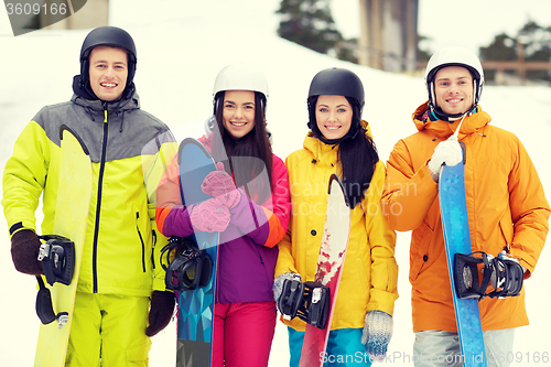 Image of happy friends in helmets with snowboards