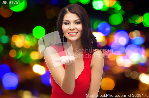 Image of beautiful woman in red dress showing empty hand