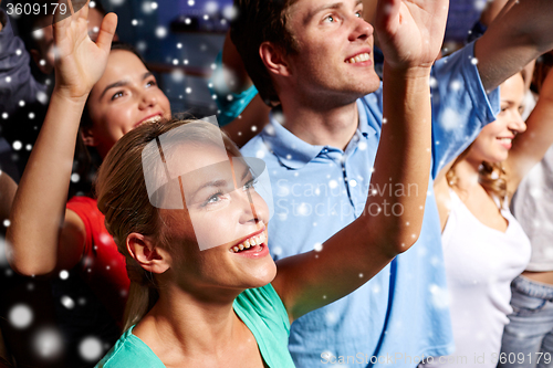 Image of smiling friends at concert in club