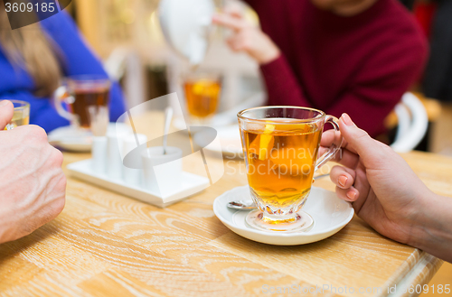 Image of close up of female hand with tea  cup at cafe