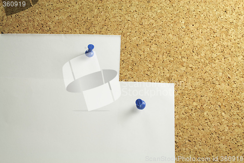 Image of white notepaper on a cork board