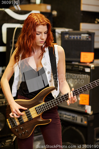 Image of musician or customer with guitar at music store