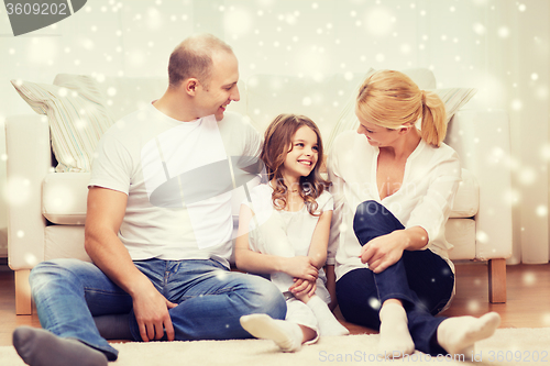 Image of smiling parents and little girl at home