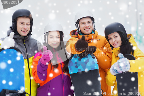 Image of happy friends in helmets with snowboards