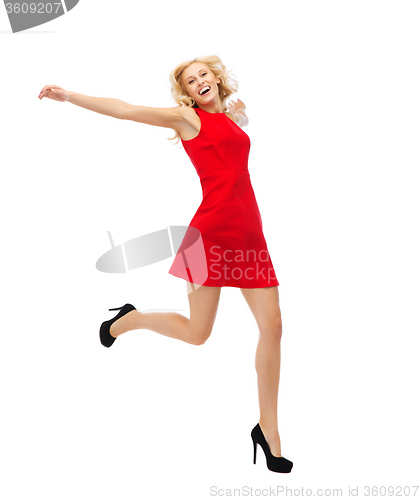 Image of happy young woman in red dress jumping high