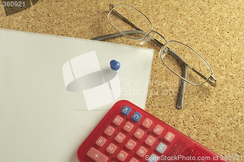 Image of spectacles and calculator on paper