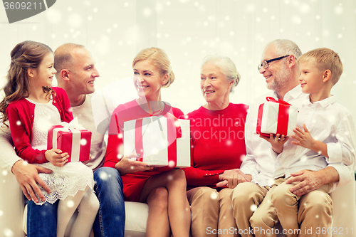 Image of smiling family with gifts at home