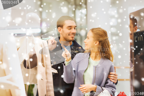 Image of happy young couple with shopping bags in mall