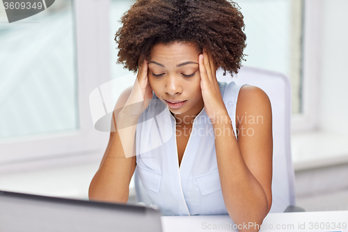 Image of african woman with laptop at office