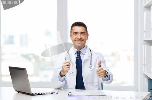 Image of smiling doctor with tablets showing thumbs up