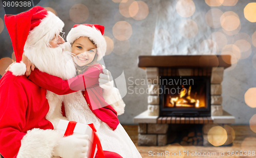 Image of smiling family with santa claus and gift at home