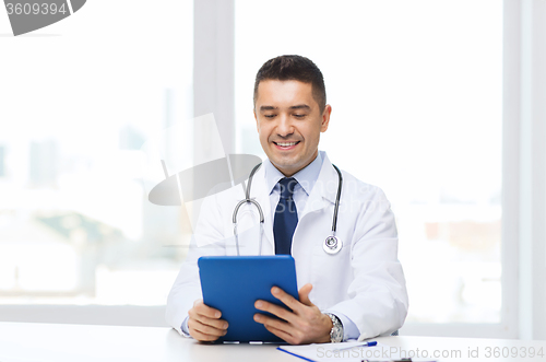 Image of smiling male doctor in white coat with tablet pc