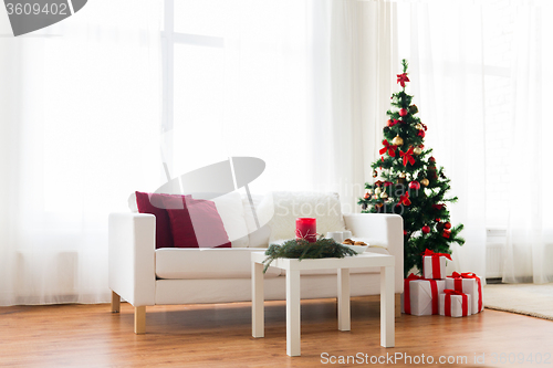 Image of sofa, table and christmas tree with gifts at home