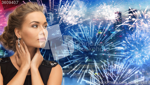 Image of beautiful woman wearing earrings over firework