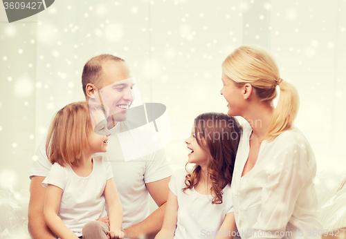 Image of smiling parents and two little girls at home