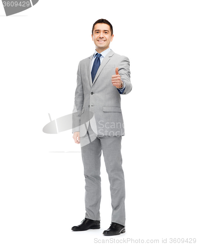 Image of happy businessman in suit showing thumbs up