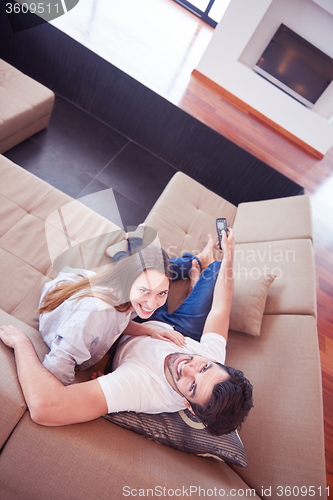 Image of young couple watching tv at home