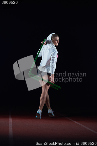 Image of woman athlete jumping over a hurdles