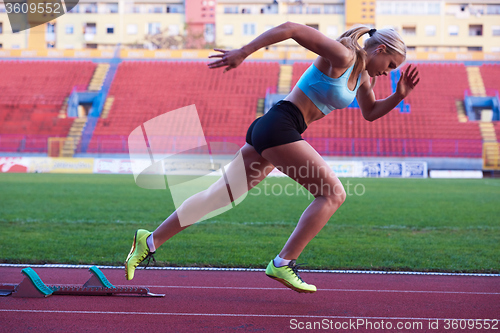 Image of pixelated design of woman  sprinter leaving starting blocks